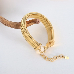 Polished 18K gold plated herringbone chain bracelet hanging on a branch