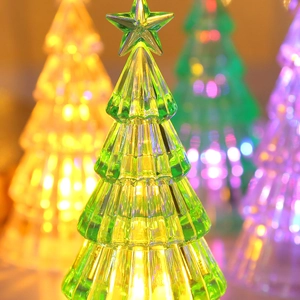 Detail of a glowing crystal mini Christmas tree with LED lights and star topper