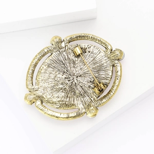 Detailed view of the golden metal back and pin structure of an oval floral brooch
