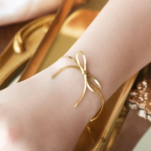 Bracciale rigido minimalista dorato con fiocco per donna con elegante finitura metallica