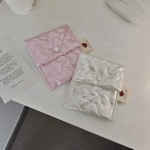 Detailed view of pink and white heart-quilted storage pouches with snap buttons