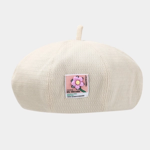 Cream waffle knit beret with a pink flower patch and stylish textured fabric