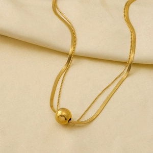 Detailed macro of gold-plated double layer necklace with sleek ball pendant