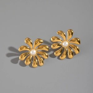 Close-up of gold flower earrings with pearls and polished stainless steel details