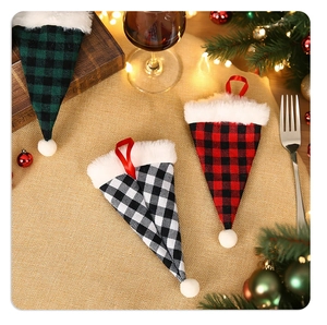 Detail of Christmas buffalo plaid cutlery holders with plush trim on festive dining table