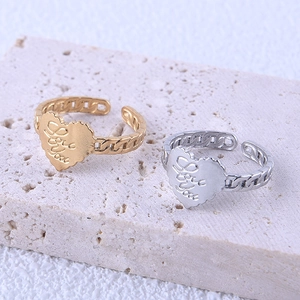 Détail macro de bagues cœur et chaîne en or et argent avec gravure Love You sur pierre