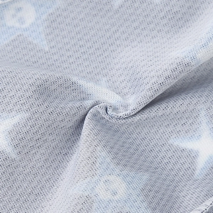 Vue macro d'un tissu tricoté respirant bleu-gris avec étoiles blanches et motifs ronds