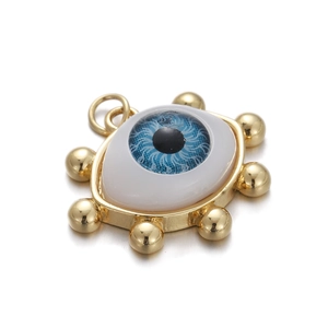 Close-up of golden Turkish evil eye pendant with blue zircon inlay on white background