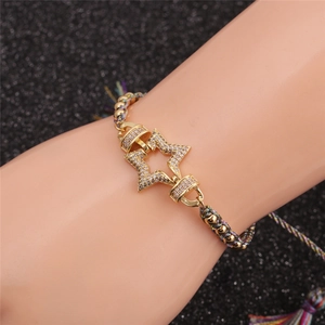 Detail eines Sternanhängers mit weißen Zirkonia auf einem handgewebten Boho-Armband