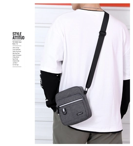 Close-up of a charcoal grey oxford fabric crossbody bag with adjustable nylon strap