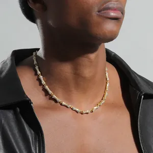 Close-up of hip hop gold dog bone necklace with sparkling crystals on male model