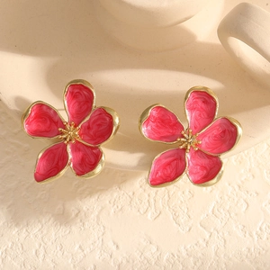 Detail of pink marble enamel flower stud earrings with golden base in a luxury style
