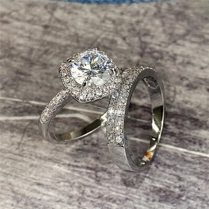 Macro shot of silver bridal ring set with halo round solitaire and paved wedding band