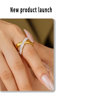 Close-up of X-shaped ring with dual-tone gold finish and micro-pave crystals on finger