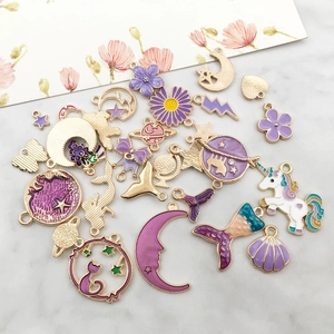 Flat lay of purple enamel charms including unicorns and stars for DIY jewelry