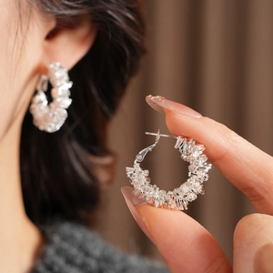 Detailed view of silver irregular geometric textured hoop earrings with a secure clasp