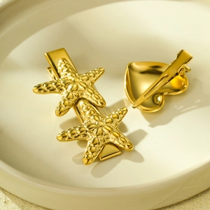 18K gold-plated stainless steel starfish and heart hairpins on a beige ceramic plate