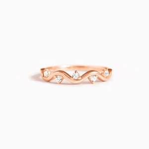 Detail of rose gold wavy ring with five prong-set round cubic zirconia crystals