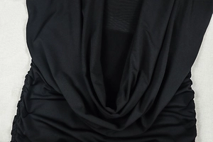 Detail of black mini dress featuring elegant ruched draping and soft pleated texture