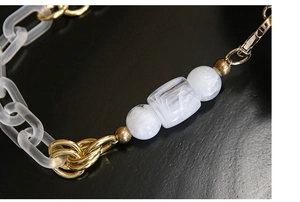 Macro shot of large capacity evening bag with acrylic chain and marble-textured beads