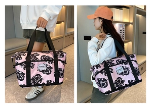 Pink canvas travel bag with elephant print shown in both hand-held and shoulder-carry modes