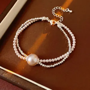 Double-layered pearl and silver bead bracelet set with a large central pearl charm