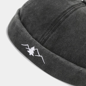 Vintage black brimless docker hat with mountain and pine forest embroidery detail
