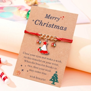 Detail of Christmas tree enamel pendant on a red hand-woven wishing bracelet with card
