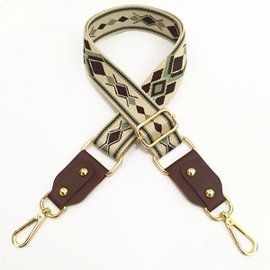 Detail of bohemian geometric woven wide strap with gold-tone hardware and brown leather