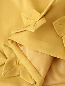 Détail macro du tissu texturé jaune montrant le tissage sergé et les coutures de qualité
