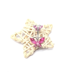 Sparkly double pink butterfly navel ring with rhinestones on a star woven background