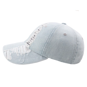 Distressed light blue washed denim baseball cap with frayed holes and vintage street style