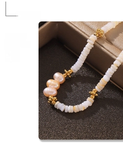 Macro shot of Baroque natural pearls and pink beads on gold plated titanium necklace