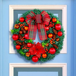 Christmas wreath with red bows, pine cones and festive berries on a blue door frame