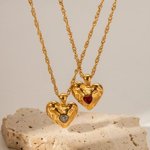Detail von 18 Karat Gold-Herzanhängern mit Hammerschlag-Textur und bunten Zirkonia