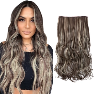 Detail of wavy clip-in hair extension in brown with light blonde highlights on white backdrop