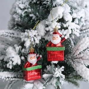 Dos adornos de Papá Noel en la chimenea colgados en un árbol de Navidad con nieve