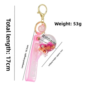 Close-up of pink Sakura lollipop keychain with quicksand glitter and golden lobster clasp