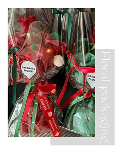 Detail of red rose gift bouquet with LED lights and Merry Christmas ribbon wrap