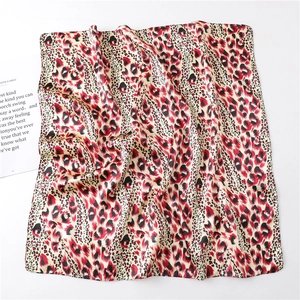 Detail of red and black leopard print silk scarf with a soft satin glossy texture