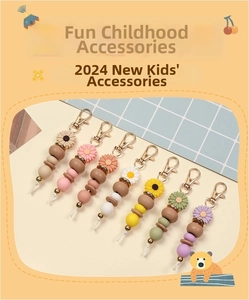 Close-up of beaded daisy keychains with colorful charms and golden lobster clasps