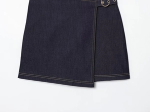 Détail de jupe en jean bleu marine avec ourlet superposé et coutures contrastées jaunes