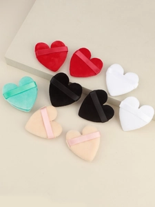 Macro shot of heart-shaped velvet makeup puffs in five colors on geometric props