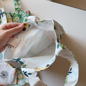 Detailed view of floral canvas tote bag showing bronze snap button closures and interior