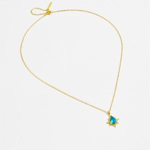 Detailed macro view of S925 sterling silver gold necklace with blue teardrop zircon
