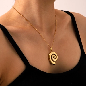 Close-up of 18k gold plated stainless steel spiral seashell pendant on a beaded chain