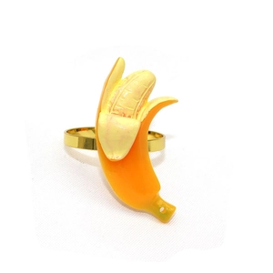 Détail d'un rond de serviette créatif en forme de banane avec anneau doré et finition jaune