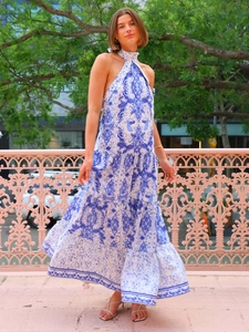 Détail de la robe longue dos nu à fleurs bleues avec des volants multicouches