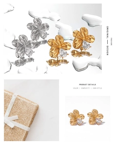 Detailed view of flower-shaped earrings with teardrop zircons in gold and silver finish