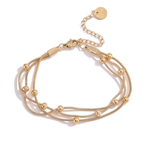 Detail of multi-layer 18K gold-plated stainless steel bracelet with beads and S.STEEL tag